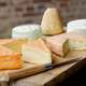 A selection of European cheeses on a wooden cutting board with a knife